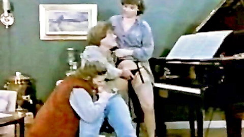 Vintage mature woman kneels licking exposed hairy pussy of seated babe on piano bench