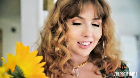 Lena Paul smiles with sunflower in Cherry Pimps video thumbnail