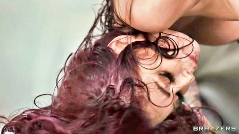 Wet purple-haired redhead throws head back with intense gaze in steamy closeup