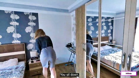 Blonde MILF bending over in short skirt, teasing in bedroom