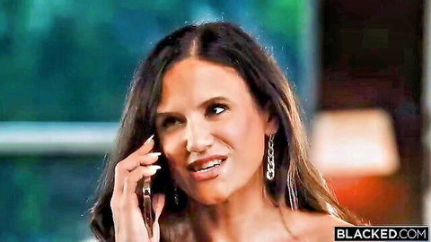 Seductive brunette MILF smirking on phone with cleavage tease in Blacked interracial preview