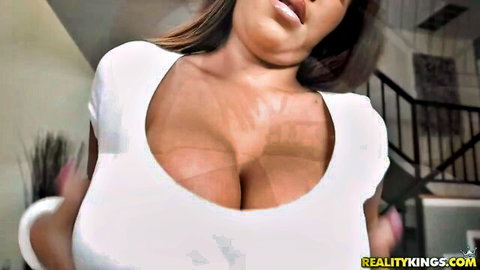 Busty brunette babe with massive tits spilling out of tight white top teasing deep cleavage