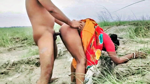 Indian woman in traditional orange saree bent over for outdoor doggy style sex