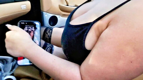 Sarah Arabic in low-cut black top showing massive cleavage in car