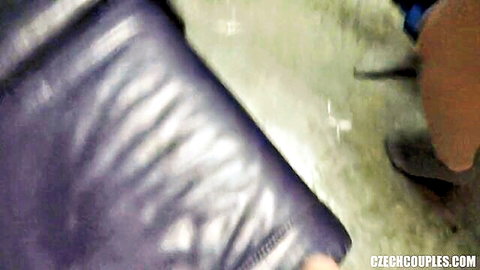 Blurry purple leather couch corner with brown shoe on green floor in Czech couples swingers room