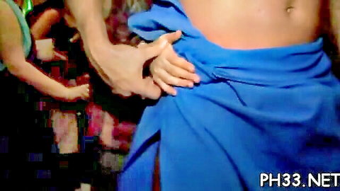 Horny women pulling blue towel off muscular guy's waist at wild neon party