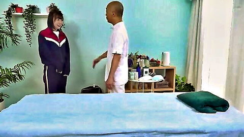 Cute Asian sporty girl in tracksuit stands with masseur in Japanese massage room