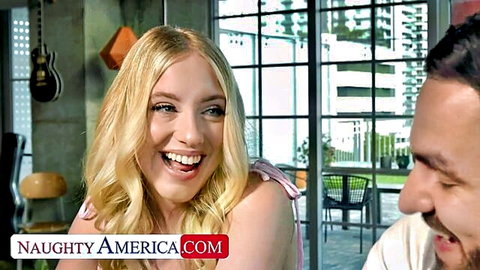 Blonde babe with huge tits smiling playfully at handsome stud in Naughty America scene