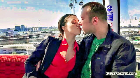 Passionate couple kissing in cable car over city skyline with PRIVATE.COM watermark