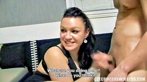 Brunette in black lingerie with smiling expression beside erect man in homemade swingers scene