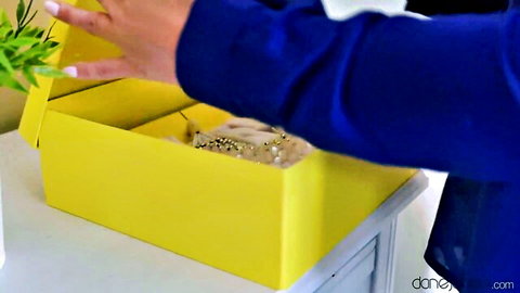 Dane Jones model opening yellow box with beige beads in cheating wife scene