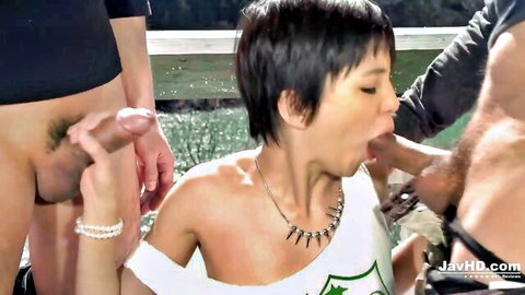 Short-haired Japanese babe sucks thick cock outdoors in threesome while another dick gropes her face