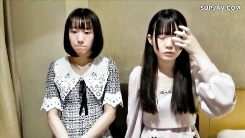 Two cute Japanese underground idols with black hair in frilly dresses, one pouting, one covering face
