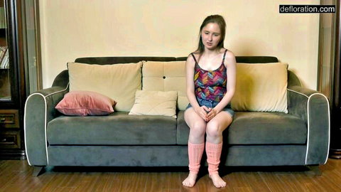 Anna Sanglante sits thoughtfully in tank top, short shorts, and pink knee socks in romantic virgin scene