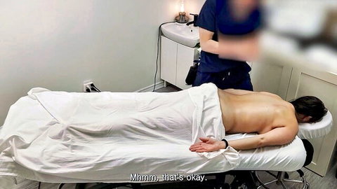White MILF lying nude under sheet during back massage by Asian man