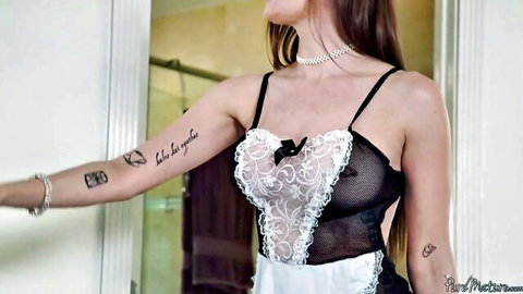 Tattooed sexy maid in sheer black lace teddy lingerie poses seductively in bathroom mirror revealing curves and tits