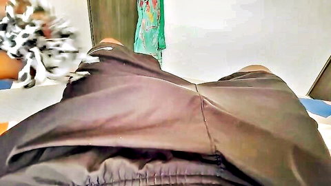 Dark-skinned thick thighs spread wide in shiny black shorts teasing cameltoe on bed