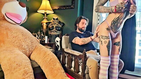 Tattooed goth girl spreads legs as bearded man fingers her bare pussy in kinky bedroom