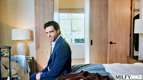 Dan Damage in blue suit on bed, teasing MILFY stepmom Serenity lingerie scene