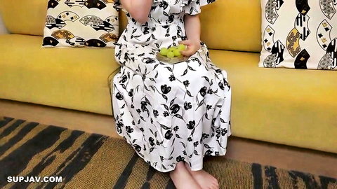 Asian woman in floral dress holds bowl of grapes, semen fetish tease