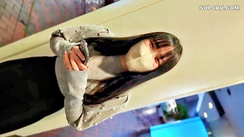 Young Japanese woman with long black hair in gray cardigan and black skirt, Tokyo arrival vibe