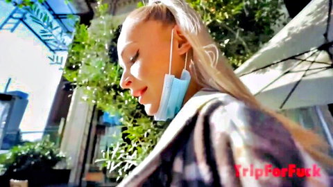 Blonde white girl in mask on public outdoor walk, raceplay theme