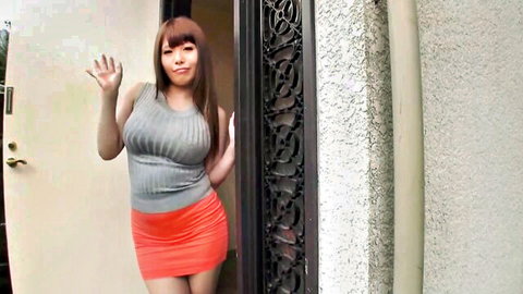 Curvy Japanese babe with big tits waves hello in tight grey top and orange miniskirt