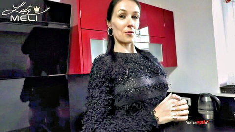 Lady Meli in sparkly black top, seductive pose in kitchen
