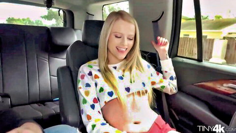 Skinny blonde teen with small tits smiling in cropped heart sweater exposing underboob in SUV backseat