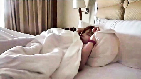 Pretty Thai katoey lying seductively in bed, teasing under sheets