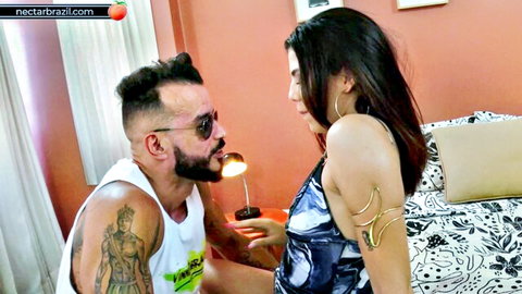 Tattooed Brazilian guy holds light on sexy brunette Latina in sheer lingerie closeup