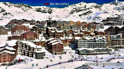Panoramic snowy ski resort village with chalets skiers and mountains in French Alps