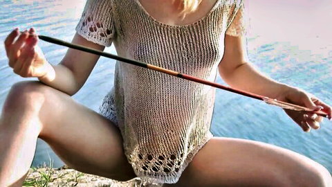 Blonde amazon squats spreading shaved pussy holding rod between thighs in sheer crochet top showing tits