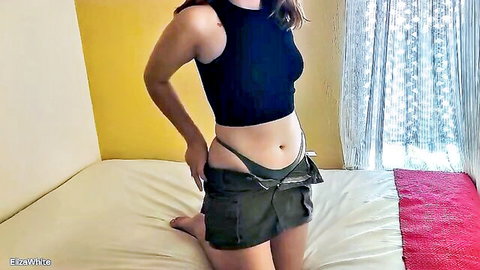 Slim brunette teen teasing in black thong and crop top, exposing midriff
