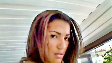 Brazilian beauty with pink-streaked hair in seductive outdoor pose
