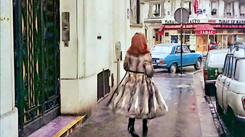 Karine Gambier in fur coat and boots walking rainy Paris street, Housewife Powers 1977