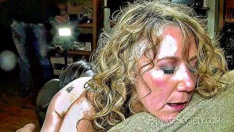Blonde MILF's flushed sweaty face and bare shoulders in intense moaning ecstasy closeup