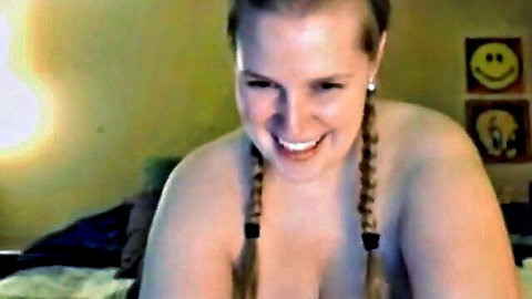 Smiling blonde with massive tits in pigtails posing topless