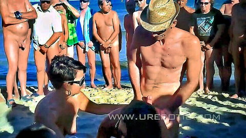 Brunette woman on crowded beach grabs naked men's cocks amid public gangbang orgy