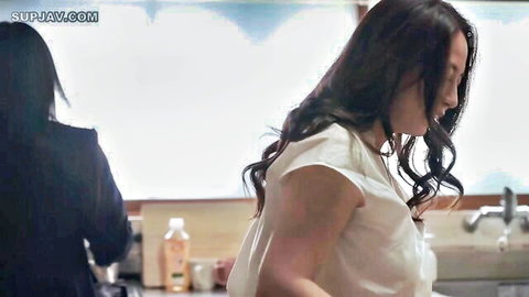 Japanese brunette in white top washing dishes at kitchen sink with another woman behind her