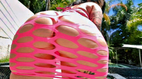 Tattooed brunette flaunts her massive fishnet-clad big ass bent over poolside