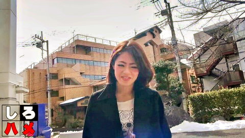 Smiling Asian woman in black coat on snowy Japanese street
