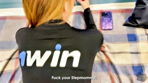 Blonde stepmom in tight black jacket sitting teasingly with phone, creampie fantasy