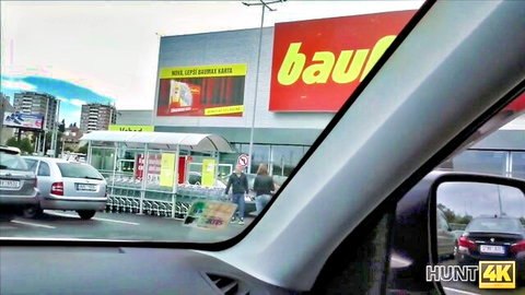 POV from car at Bauhaus store parking lot with shoppers before escort public fuck