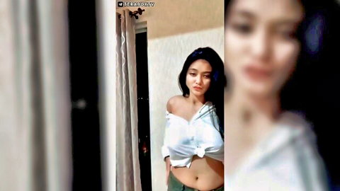 Asian babe with big tits teasing in tied white off-shoulder top exposing cleavage and abs