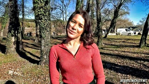 Melisa Rose smiling outdoors in fitted red sweater, sunny park setting