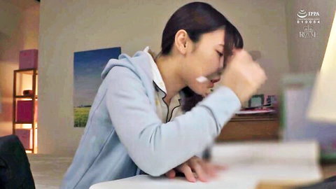 Mei Satsuki in emotional JAV moment, wearing blue hoodie at table
