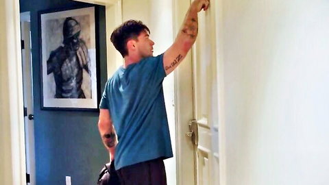 Tattooed Leeroy Jones in dominant pose, arm extended in hallway