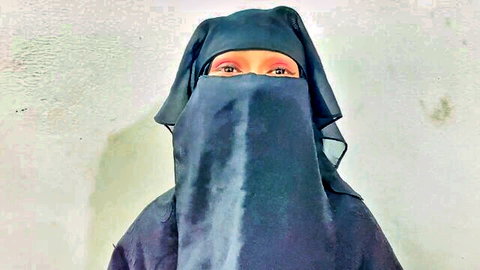 Seductive Muslim woman in black niqab with alluring red eyes teasing for hijab sex
