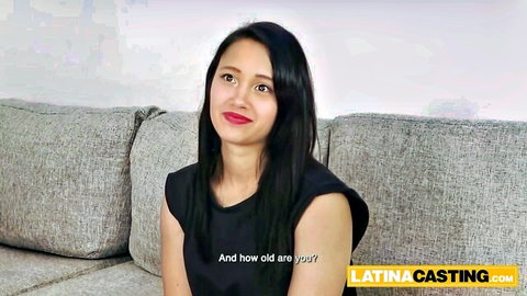 Smiling Latina beauty in black tank top during casting interview, long dark hair